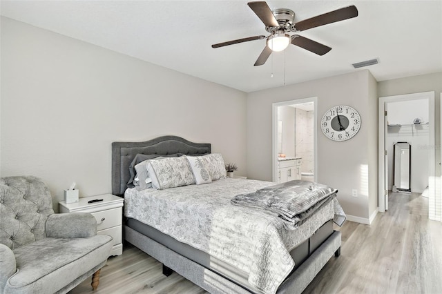 bedroom featuring ceiling fan, ensuite bath, and light wood-type flooring