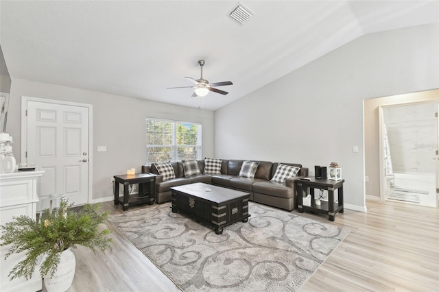 living room featuring ceiling fan, vaulted ceiling, and wood-type flooring