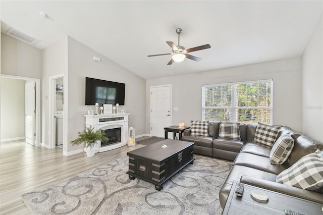 living room with hardwood / wood-style flooring, lofted ceiling, and ceiling fan