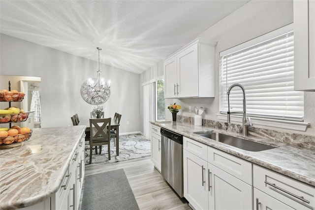 kitchen with sink, dishwasher, light stone counters, white cabinets, and decorative light fixtures