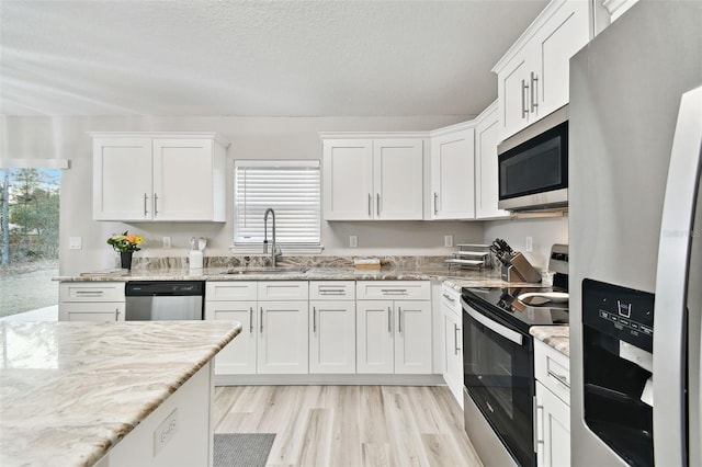 kitchen with stainless steel appliances, sink, and white cabinets