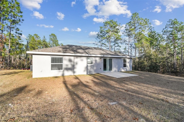 back of property featuring a patio and a yard