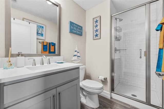 bathroom featuring walk in shower, vanity, and toilet