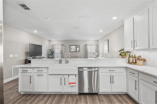 kitchen with sink, white cabinetry, light hardwood / wood-style flooring, stainless steel dishwasher, and kitchen peninsula