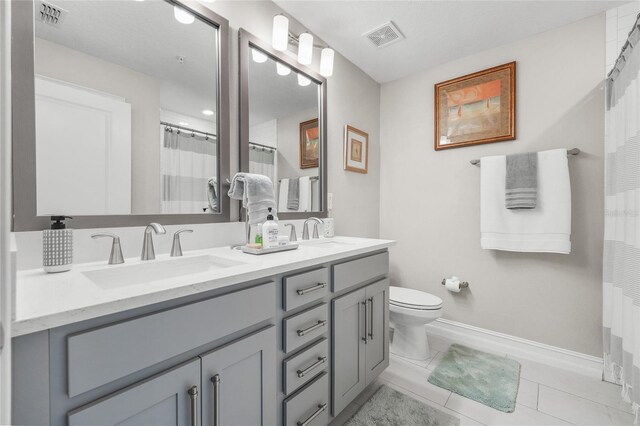 bathroom featuring a shower with curtain, tile patterned floors, vanity, and toilet