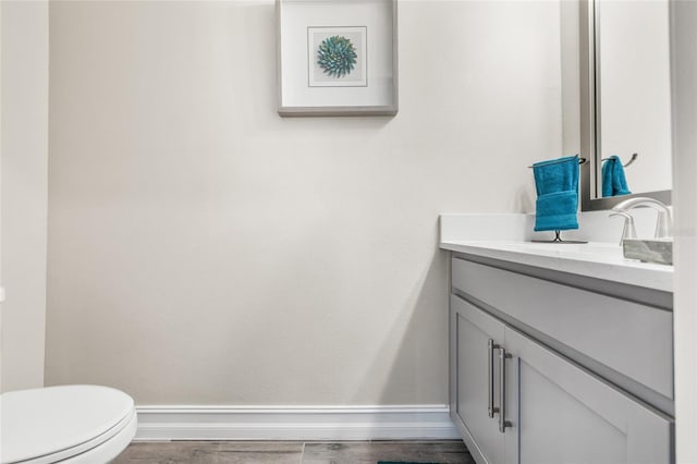 bathroom with hardwood / wood-style flooring, vanity, and toilet