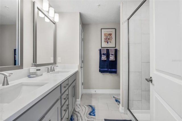 bathroom featuring vanity, tile patterned floors, an enclosed shower, and a textured ceiling