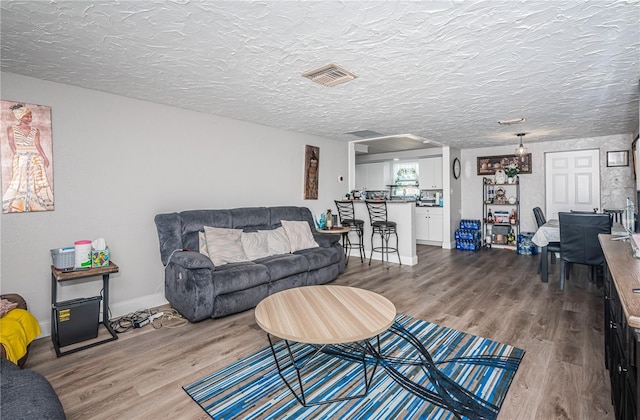 living room with hardwood / wood-style flooring and a textured ceiling