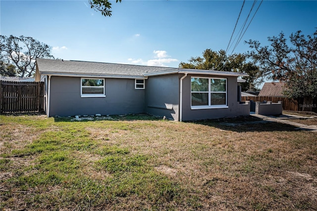 rear view of house featuring a lawn