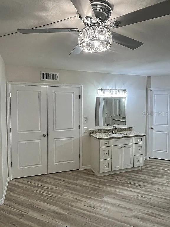 bathroom with hardwood / wood-style flooring, vanity, and ceiling fan