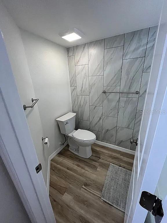 bathroom with toilet and hardwood / wood-style floors