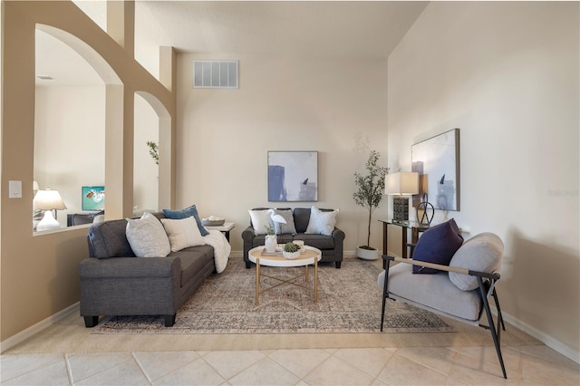 tiled living room with a towering ceiling