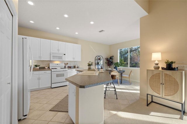 kitchen featuring light tile patterned flooring, white appliances, decorative backsplash, and white cabinets