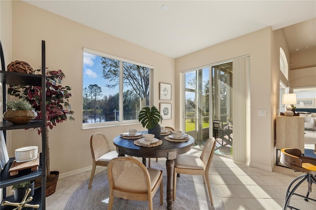 dining room featuring a water view and light tile patterned flooring