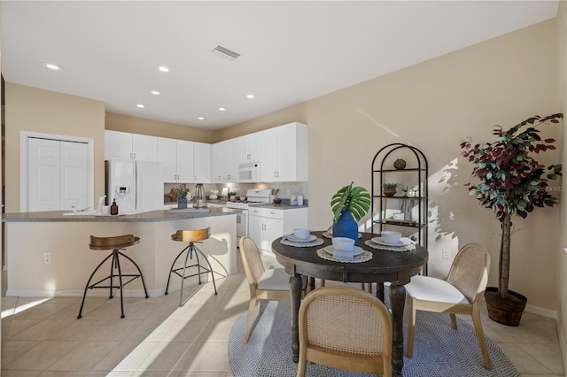 dining space with sink and light tile patterned floors