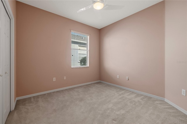 carpeted spare room with ceiling fan