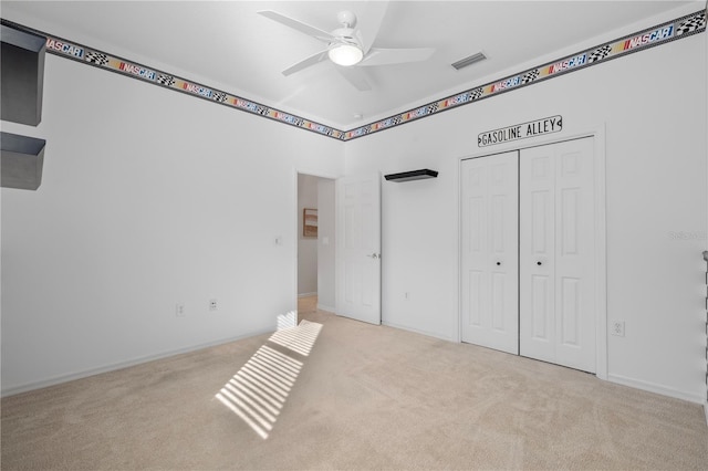 unfurnished bedroom featuring light carpet, a closet, and ceiling fan