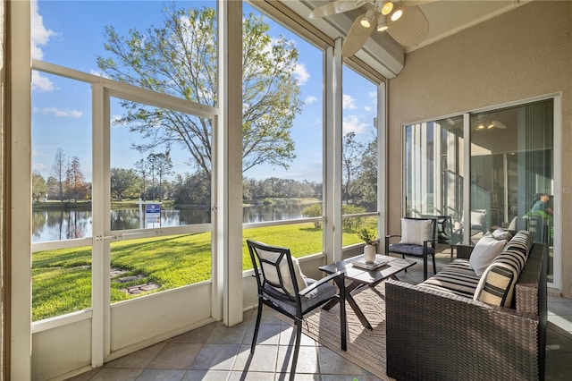 sunroom featuring ceiling fan and a water view