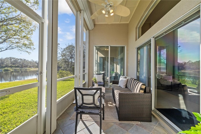 sunroom / solarium featuring a water view and ceiling fan