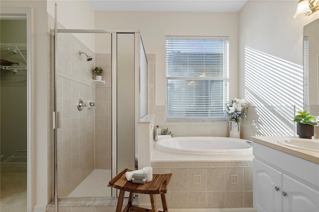 bathroom featuring vanity, plus walk in shower, and plenty of natural light