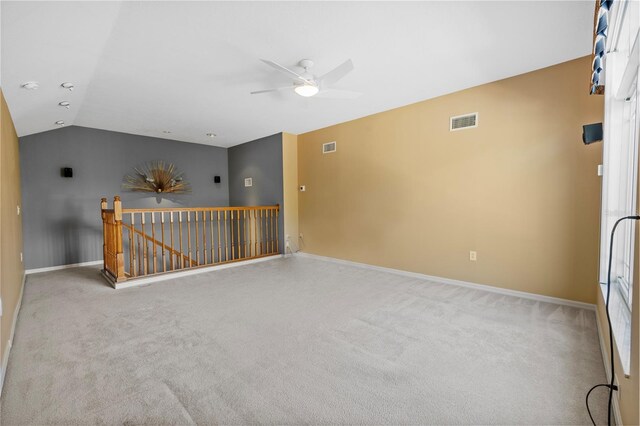 spare room with vaulted ceiling, light colored carpet, and ceiling fan