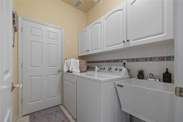 clothes washing area featuring cabinets, light tile patterned flooring, separate washer and dryer, and sink