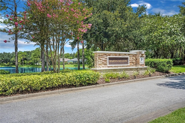 community sign featuring a water view