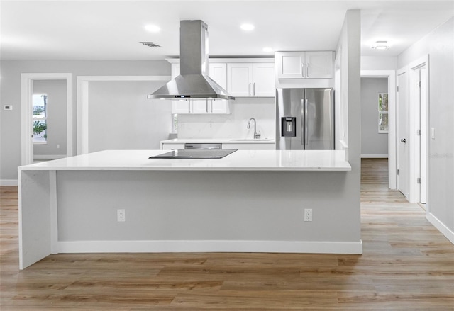 kitchen featuring sink, white cabinets, island exhaust hood, stainless steel refrigerator with ice dispenser, and light wood-type flooring