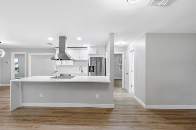 kitchen featuring sink, white cabinetry, stainless steel refrigerator with ice dispenser, island range hood, and light wood-type flooring