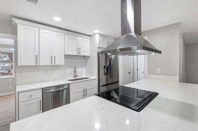 kitchen featuring island range hood, sink, white cabinets, stainless steel appliances, and light stone countertops