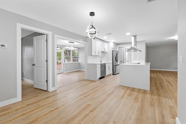 kitchen featuring white cabinetry, light hardwood / wood-style flooring, pendant lighting, island exhaust hood, and stainless steel appliances