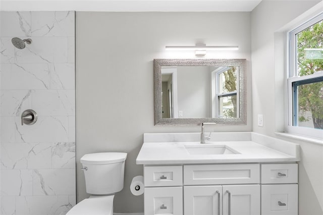 bathroom featuring vanity, toilet, and tiled shower