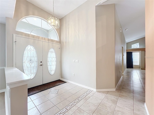 foyer with an inviting chandelier, high vaulted ceiling, and light tile patterned flooring