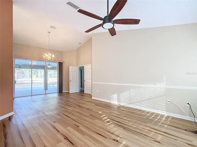 empty room with ceiling fan with notable chandelier, high vaulted ceiling, and light wood-type flooring