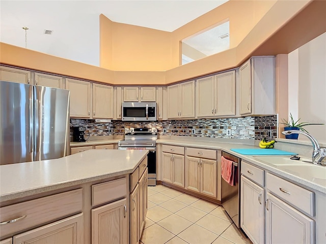 kitchen with stainless steel appliances, sink, light tile patterned floors, and backsplash