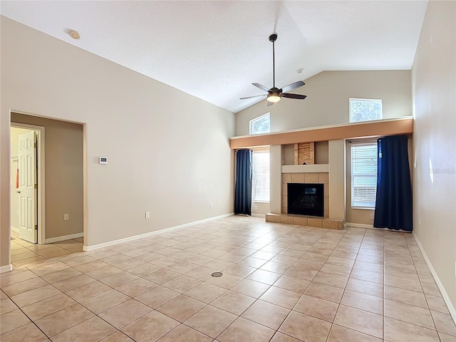 unfurnished living room with light tile patterned flooring, high vaulted ceiling, a tiled fireplace, ceiling fan, and a textured ceiling