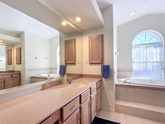 bathroom with tile patterned flooring, vanity, a relaxing tiled tub, and vaulted ceiling