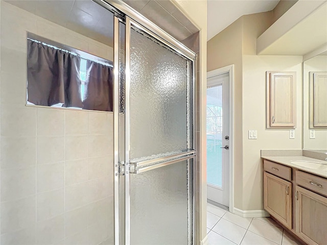 bathroom featuring vanity, a shower with shower door, and tile patterned flooring