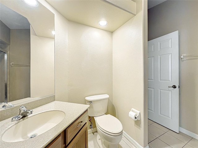 bathroom featuring vanity, tile patterned floors, and toilet