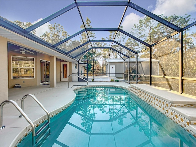 view of swimming pool featuring ceiling fan, a patio, and glass enclosure