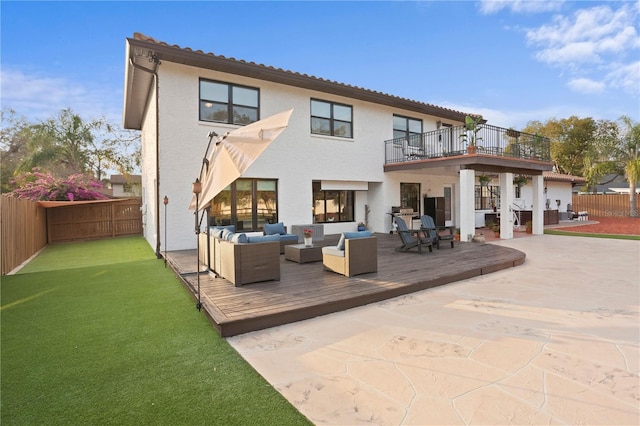 back of house featuring a patio, a balcony, a deck, an outdoor hangout area, and a yard