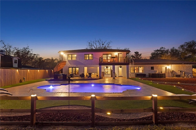 pool at dusk featuring a patio