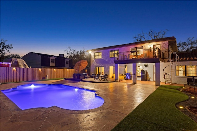 pool at dusk featuring a patio area