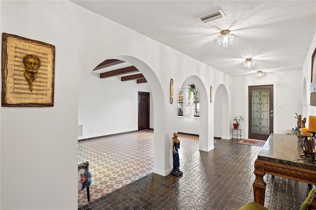 entryway with a textured ceiling and beam ceiling