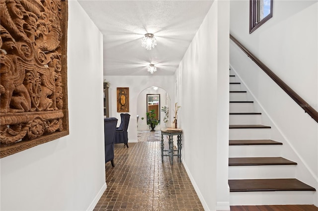 hall featuring a textured ceiling