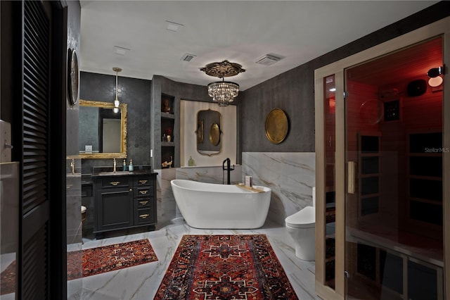 bathroom with vanity, a tub, a notable chandelier, and toilet