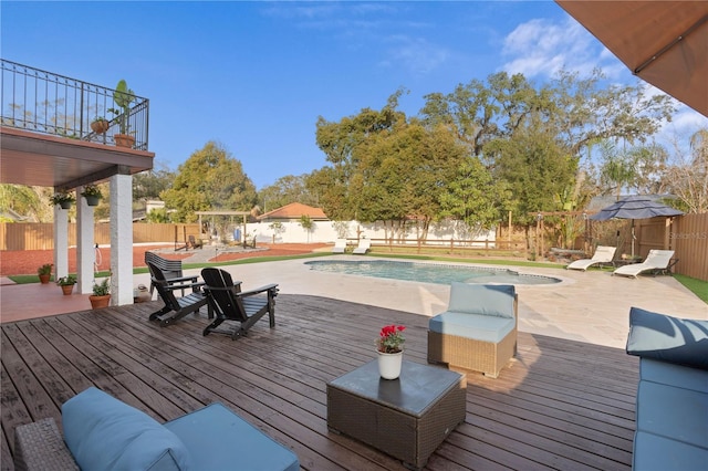 deck featuring a fenced in pool, a patio, and a pergola