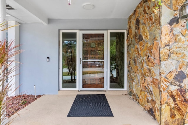 entrance to property featuring stucco siding