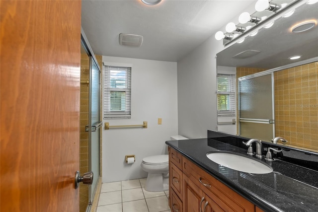 bathroom featuring vanity, tile patterned floors, toilet, and walk in shower