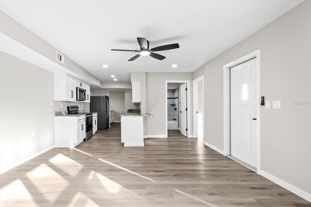 kitchen featuring ceiling fan, stainless steel appliances, hardwood / wood-style floors, and white cabinets